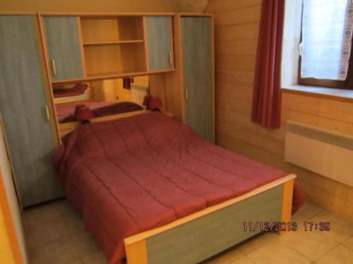 a small bedroom with a bed with a red cover at Appartement 8 pers. avec vue montagne 70848 in Saint-Sorlin-dʼArves