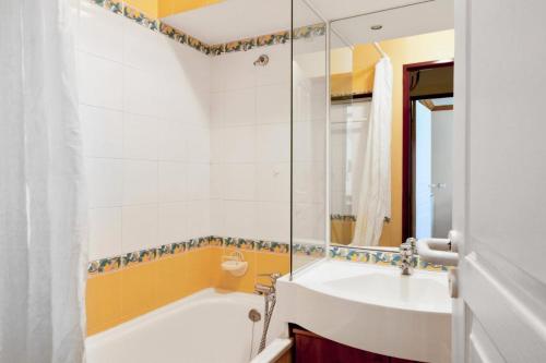 une salle de bain avec une baignoire et un lavabo dans l'établissement Résidence La Marelle et Le Rami - maeva Home - 2 Pièces 5 Personnes Confort MAE-0757, à La Plagne Tarentaise