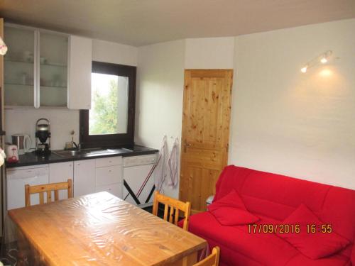 un salon avec un canapé rouge et une table dans l'établissement Studio 4 pers. avec grande terrasse - Studio 4 personnes MAE-2995, à Saint-Gervais-les-Bains