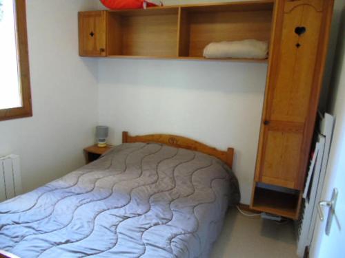 a bedroom with a bed and wooden shelves at Chalet Arrondaz - 3 Pièces pour 8 Personnes MAE-8754 in Modane