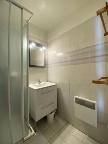 une salle de bain blanche avec un lavabo et une douche dans l'établissement Résidence Lac Du Lou - VAL THORENS location: Appartement de 38 m2 au 7ème étage, skis aux pieds, balcon exposé sud MAE-9021, à Val Thorens