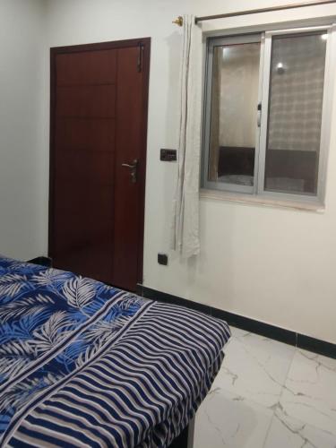 1 dormitorio con cama y ventana en Comfy room, en Rawalpindi