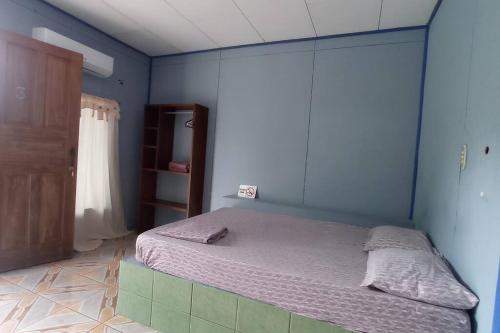 een slaapkamer met een bed in een blauwe kamer bij Cabinas Centro Social Volio #6 in Talamanca