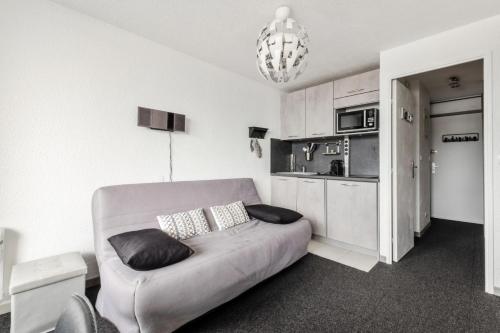 Il comprend un salon avec un canapé gris et une cuisine. dans l'établissement Studio 4 pers. pied des pistes - maeva Home - Studio moderne 4 personnes au pied des pistes - Sélection - Super Home MAE-3345, à Morzine