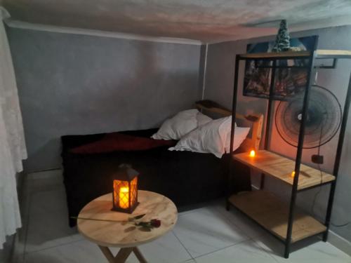 a small room with a bed and a table with a candle at Pra la Vue in Durban