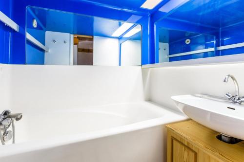 La salle de bains est pourvue d'un lavabo blanc et de plafonds bleus. dans l'établissement Résidences quartier Charmettoger - maeva Home - 2 Pièces 6 Personnes Budget MAE-3506, à Arc 1800