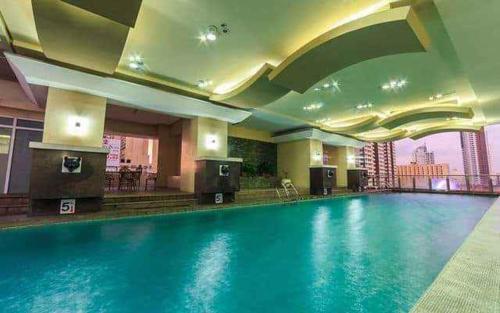 a large swimming pool in a hotel room at Experience OCEAN VIEW Rooms in The Heart Of Manila, Enjoy FREE ACCESS To The POOL, SAUNA, PLUS MASSAGE PROMO In Prime Location Near The US Embassy, NAIA, Makati, BGC, Mall of Asia, And Chinatown This Is A Limited-Time Offer, Book Now in Manila