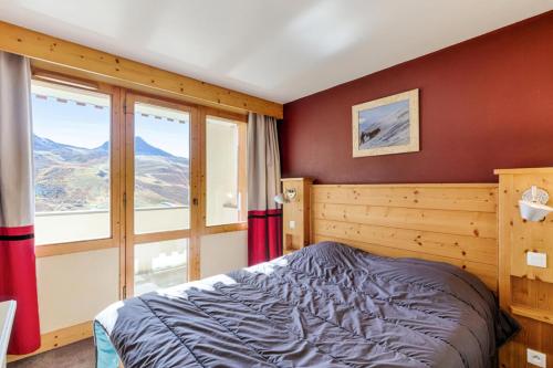une chambre avec un lit et une grande fenêtre dans l'établissement Résidence Les Néreïdes - maeva Home - 3 Pièces 7 Personnes Prestige MAE-3987, à La Plagne Tarentaise