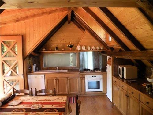 una cocina con armarios de madera y un ático en Gîte de France La gloire 3 épis - Gîte de France 4 personnes MAE-6514, en Noual