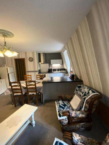 un salon avec un canapé et des chaises et une cuisine dans l'établissement Gîte de France à Lissac sur Couze 3 épis - Gîte de France 4 personnes MAE-6524, à Lissac-sur-Couze