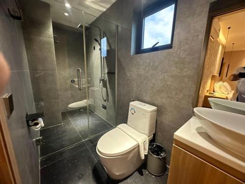 a bathroom with a toilet and a shower and a sink at SF HOTEL Penthouse Residences in Phnom Penh