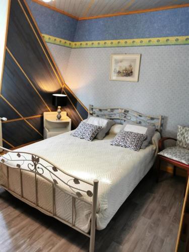 une chambre avec un grand lit et une chaise dans l'établissement Gîte de France à Lissac sur Couze 3 épis - Gîte de France 4 personnes MAE-6524, à Lissac-sur-Couze