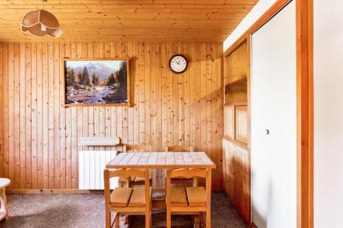 une salle à manger avec une table et une horloge au mur dans l'établissement Chalet le Séchet - maeva Home - 2 Pièces 4 personnes Confort MAE-0622, à Bellentre