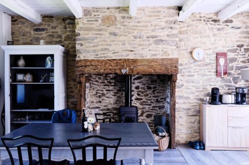 uma sala de jantar com uma mesa e uma parede de pedra em Gîte de France Les figuiers 3 épis - Gîte de France 4 personnes 544 