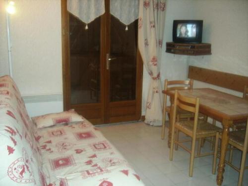 - un salon avec une table, un canapé et une télévision dans l'établissement Appartement 4 pers. avec balcon vue montagne - 2 Pièces 5 personnes MAE-0642, à Saint-Sorlin-dʼArves