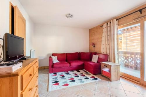 un salon avec un canapé rouge et une télévision dans l'établissement Appartement 3 pièces 6 pers proche pistes - maeva Home - 3 Pièces 6 Personnes Sélection MAE-4880, à Arâches-la-Frasse