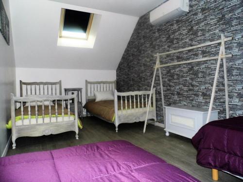 une chambre avec deux lits et un mur de briques dans l'établissement Gîte de France à Lissac sur Couze 3 épis - Gîte de France 8 personnes MAE-6554, à Lissac-sur-Couze