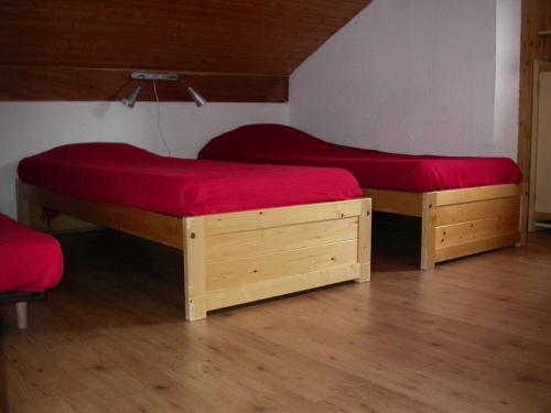 two beds with red sheets in a room at Appartement à Belle Plagne à 150m des pistes 70902 in La Plagne