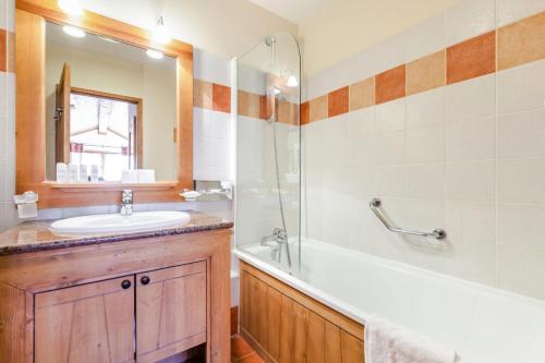 une salle de bain avec un lavabo, une baignoire et une douche dans l'établissement Résidence Les Arcs 1950 Le Village - maeva Home - 6 pièces 12 personnes Sélection MAE-4760, à Bourg-Saint-Maurice