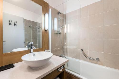 W łazience znajduje się biała umywalka i prysznic. w obiekcie Résidence Les terrasses d'Eos - maeva Home - 3 Pièces 6 Personnes - Sélect 67 w mieście Flaine