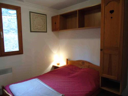 - une chambre avec un lit doté d'un couvre-lit rouge et d'une fenêtre dans l'établissement Chalet Arrondaz - 3 Pièces pour 8 Personnes MAE-8744, à Modane