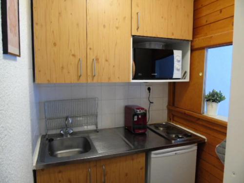 une petite cuisine avec un évier et un micro-ondes dans l'établissement Résidence Thabor - Studio pour 3 Personnes MAE-8894, à Modane