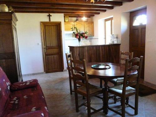 une salle à manger avec une table et une cuisine dans l'établissement Gîte de France à Saillac 2 épis - Gîte de France 2 personnes MAE-6334, à Saillac