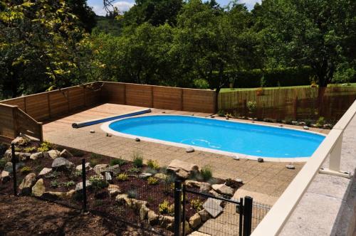 una piscina en un jardín junto a una valla en Gîte de France Aux deux mésanges 4 épis - Gîte de France 10 personnes MAE-6364, en Sainte-Fortunade