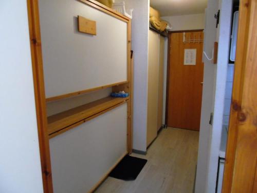 un couloir avec une porte blanche et une étagère en bois dans l'établissement Résidence Melezets - Studio pour 3 Personnes MAE-8964, à Modane