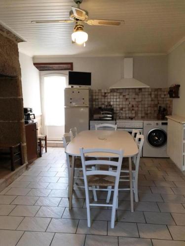 une cuisine avec une table et des chaises dans une pièce dans l'établissement Gîte de France Chez mamie 2 épis - Gîte de France 4 personnes MAE-6584, à Lissac-sur-Couze
