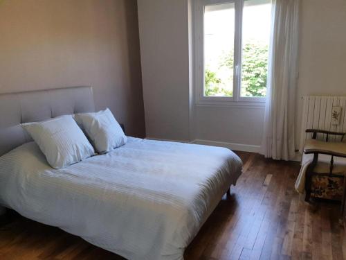 une chambre avec un lit blanc avec une fenêtre dans l'établissement Gîte de France Chez mamie 2 épis - Gîte de France 4 personnes MAE-6584, à Lissac-sur-Couze