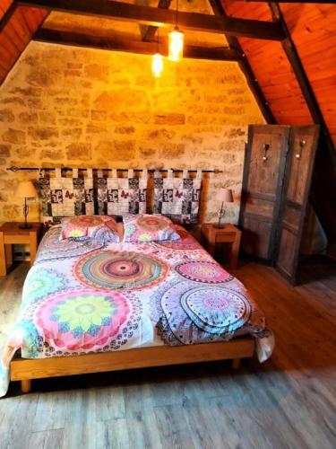 une chambre avec un grand lit dans un grenier dans l'établissement Gîte de France Gîte joulebois 3 épis - Gîte de France 4 personnes MAE-6444, à Saillac