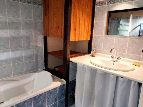La salle de bains est pourvue d'un lavabo et d'une baignoire. dans l'établissement Gîte de France à Saillac 3 épis - Gîte de France 4 personnes 444, à Saillac