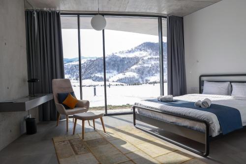 a bedroom with a bed and a chair and a large window at Concept Hotel by COAF in Debed