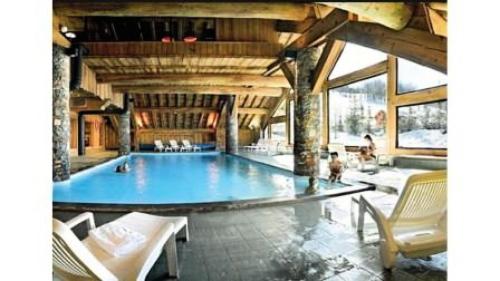 - une grande piscine dans une grande pièce avec des chaises dans l'établissement Résidence Les Alpages de Reberty - maeva Home - 3 Pièces 8 Personnes Prestige MAE-4042, aux Menuires