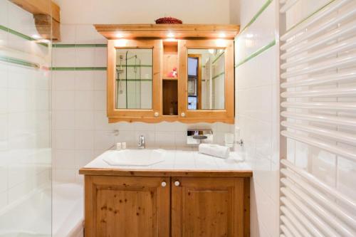 une salle de bain avec un lavabo et un miroir dans l'établissement Résidence Les Alpages de Reberty - maeva Home - 3 Pièces 8 Personnes Prestige MAE-4042, aux Menuires