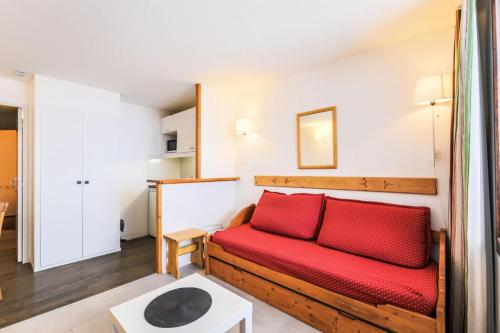 - un salon avec un canapé rouge dans l'établissement Résidence Les Mélèzes - maeva Home - 2 Pièces 6 Personnes Sélection MAE-5685, à Huez