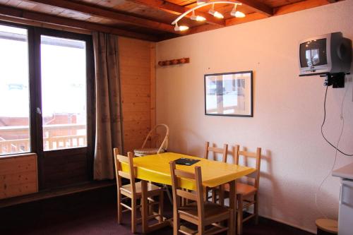 une salle à manger avec une table et des chaises jaunes dans l'établissement Résidence Lac Blanc - VAL THORENS location: studio pour 4 personnes oriénté sud ouest résidence Lac Blanc MAE-9050, à Val Thorens