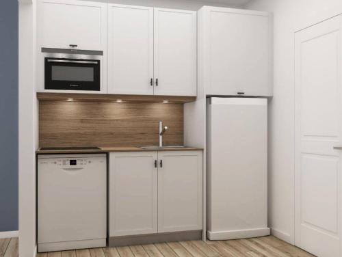 uma cozinha branca com armários brancos e um lavatório em Résidence La Rivière - maeva Home - Appartement 2 pièces 6 personnes - Sé 71 em Chamonix-Mont-Blanc