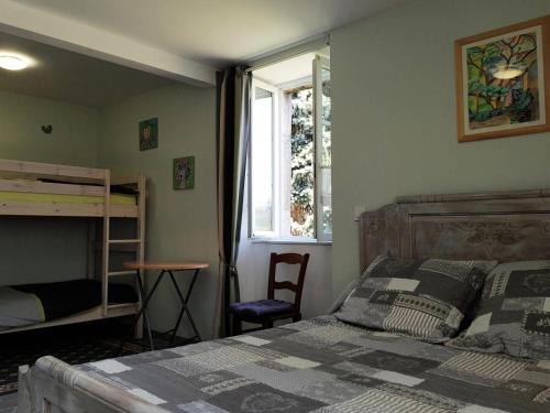 Schlafzimmer mit einem Bett, einem Schreibtisch und einem Fenster in der Unterkunft Gîte de France Au bord de l'eau 3 épis - Gîte de France 6 personnes 674 in Aubazines
