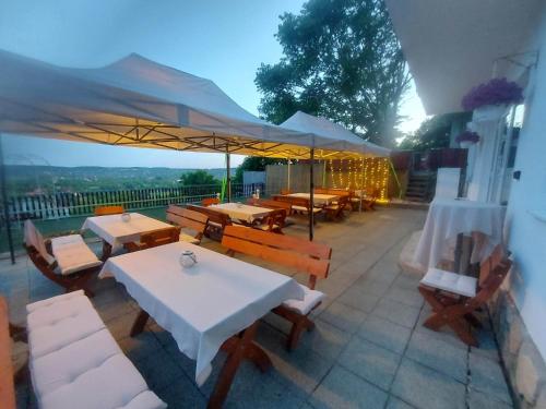 een patio met tafels, stoelen en parasols bij Attila's Guest House in Budaörs