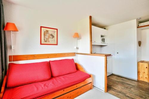 - un salon avec un canapé rouge dans l'établissement Résidence Les Mélèzes - maeva Home - Appartement skis aux pieds vue montagne 2 pièces 4 personnes - Sélection MAE-9791, à Huez