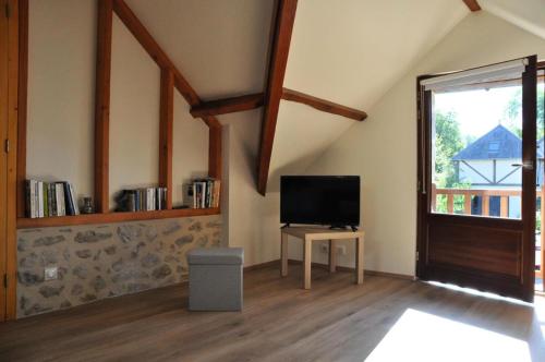 a living room with a tv and a window at Gîte de France Le fournil 3 épis - Gîte de France 2 personnes MAE-6664 in Marcillac-la-Croisille