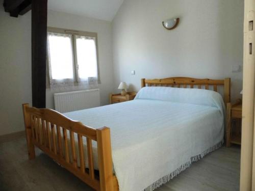 une chambre avec un lit en bois et une fenêtre dans l'établissement Gîte de France Le doustre 2 épis - Gîte de France 4 personnes MAE-8914, à Argentat