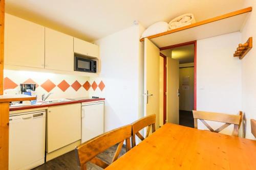 une cuisine avec une table en bois et une salle à manger dans l'établissement Résidence Les Mélèzes - maeva Home - Studio 5 personnes - Sélection MAE-1344, à Huez