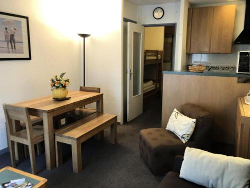 Il comprend un petit salon avec une table et une cuisine. dans l'établissement Résidence MARMOTTES - Studio pour 4 Personnes MAE-8924, à Gourette