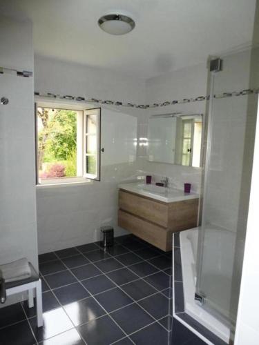 une salle de bain avec une baignoire, un lavabo et une fenêtre dans l'établissement Gîte de France à Albussac 4 épis - Gîte de France 6 personnes MAE-8924, à Albussac