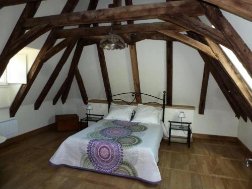 Gîte de France Chez le fustier 4 épis - Gîte de France 6 personnes MAE-8924 في Albussac: غرفة نوم بسرير كبير في العلية