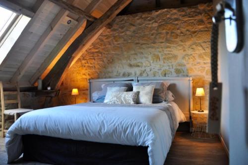 1 dormitorio con 1 cama en una pared de piedra en Gîte de France La fourche à javelles 4 épis - Gîte de France 5 personnes 684, en Yssandon