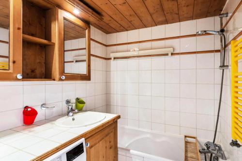 une salle de bain avec un lavabo et une baignoire dans l'établissement Résidence La Ginabelle - maeva Home - 4 Pièces 6 Personnes - Prestige MAE-1506, à Chamonix-Mont-Blanc